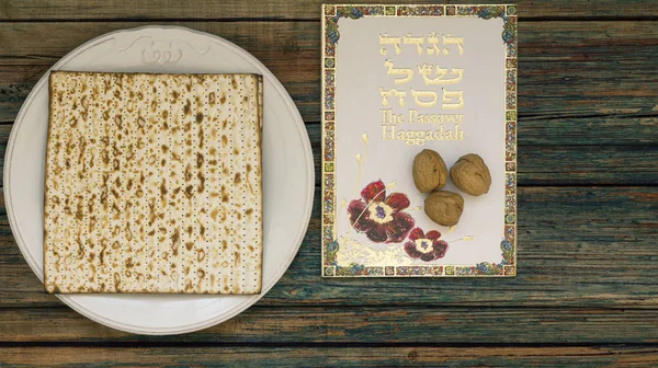 Vintage ahşap arka plan beyaz tabakta matzah veya matza ve Fısıh Haggadah seder Fısıh Bayramı veya kopya alanı ile bir yemek olarak sundu. Fısıh tasarımınız için mükemmel