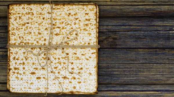 Yığın matzah veya matza vintage ahşap arka plan üzerinde bir hediye olarak sundu. Fısıh tasarımınız için mükemmel