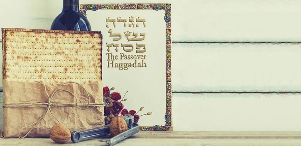 Matzah veya matza, Pesah Haggadah ve vintage ahşap arka plan üzerinde koşer kırmızı şarap paket. Kopya alanı ile Yahudi Fısıh Bayramı tatil kompozisyon. İbranice metin çevirisi: Passove hikayesi