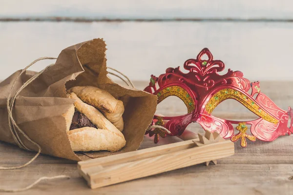 Purim Yahudi Bayramı kompozisyon hamantaschen, purim maskesi ile purim gragger kopya spac bir vintage ahşap zemin üzerine