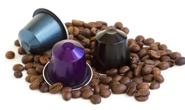 İtalyan espresso kahve kapsül veya beyaz izole arka planda bazı kavrulmuş kahve çekirdekleri ile kahve pods