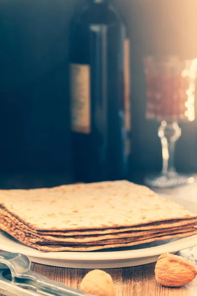 Matzah veya matza vintage bir ahşap masa üzerinde beyaz plakalı seder Fısıh Bayramı veya yemek ile karanlık mermer veya taş arka plan olarak sunulan