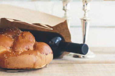 Şabat veya Sabbath bakkal alışveriş bir geleneksel tatlı taze somun challah ekmek vintage ahşap arka plan üzerinde kırmızı koşer şarap bir şişe ile kompozisyon