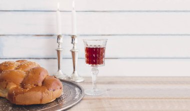 Şabat veya challah ekmek, kadeh kırmızı koşer şarap ve mumlar kopya alanı vintage bir ahşap zemin üzerine bir geleneksel tatlı taze somun ile Sabbath Birliği töreni kompozisyon