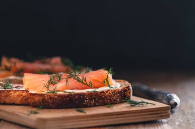 Kızarmış ekmekle birlikte füme somonlu sandviç aperatifi.