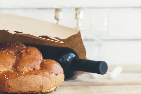 Şabat veya Sabbath bakkal alışveriş bir geleneksel tatlı taze somun challah ekmek vintage ahşap arka plan üzerinde kırmızı koşer şarap bir şişe ile kompozisyon