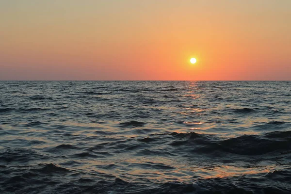 O sol, cansado durante o dia, encontra a paz além da linha do horizonte — Fotografia de Stock