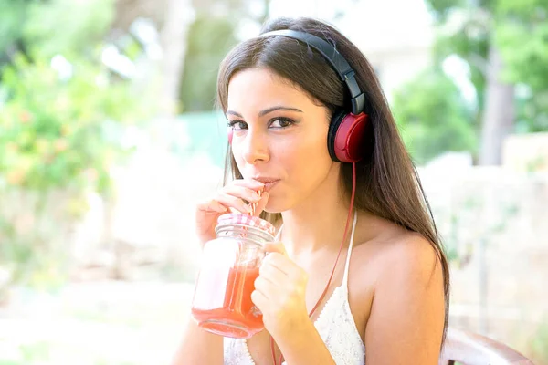 リラックスした時間で笑顔の女の子夏の時間で屋外でオレンジジュースを飲んで — ストック写真
