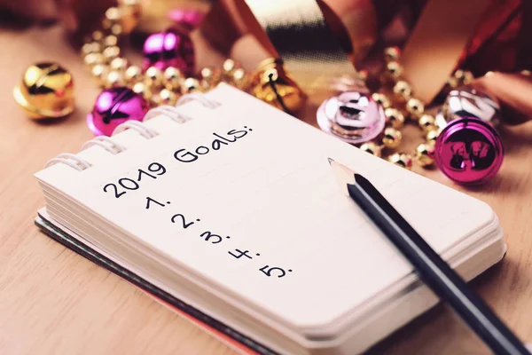 Goals 2019 with gold decoration. Discover how setting goals can bring more happiness in your life.