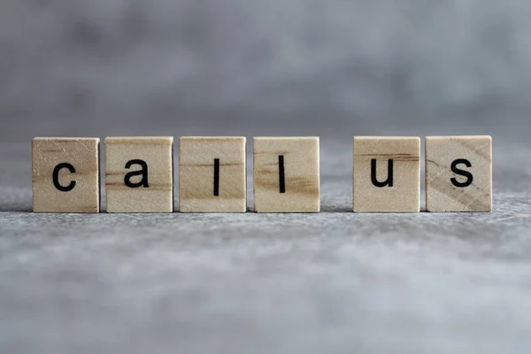 Llámenos palabra escrita en cubo de madera — Foto de Stock