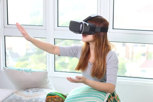 Junge Frau trägt Virtual-Reality-Brille zu Hause. — Stockfoto