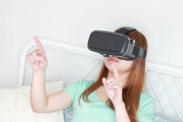 Młoda kobieta w domu sobie okulary wirtualnej rzeczywistości. — Zdjęcie stockowe