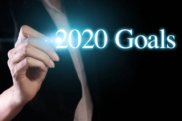 Mão segurando uma caneta e escrevendo metas 2020 — Fotografia de Stock