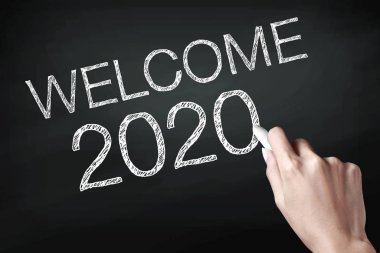El bir tebeşir tutarak ve 2020 hoş geldiniz yazma