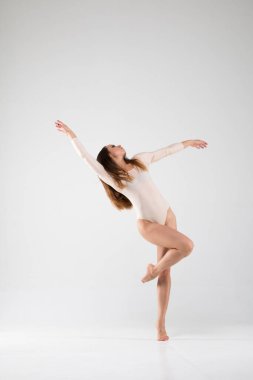 Beyaz bir arka planda dans eden alışılmadık bir balerin. Sanat, tarz, arka plan, zarif, pahalı, lüks, şaşırtıcı, modern.