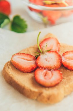 Beyaz arka planda taze çilekli fıstık ezmeli sandviç. Sağlıklı yaz kahvaltısı ya da atıştırmalık.