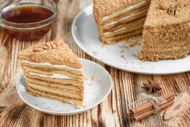 Ev yapımı ballı kek, fındıklı ve beyaz tabakta, ahşap masada..