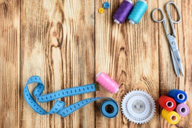 Ahşap masada iplikler ve dikiş aksesuarları