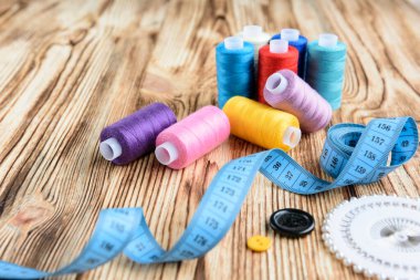Ahşap masada iplikler ve dikiş aksesuarları
