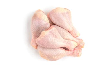Tahta kesme tahtasındaki çiğ tavuk bacakları beyaz arka planda izole edilmiş..