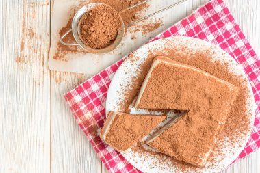 Beyaz ahşap masada kakaolu ev yapımı süzme peynir sufle tatlısı.
