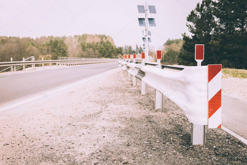 Bridge with road barriers near forest.