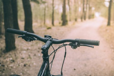 Bisikletle tepeden aşağıya doğru hızla inen dağ bisikleti. Motorcuların gözlerinden görüntü. Bisiklet gidonunu kapat.