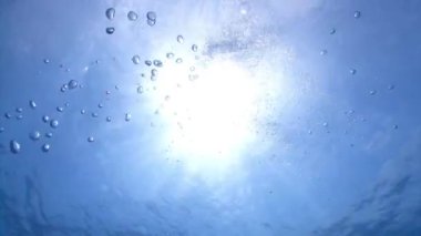 Hava kabarcıkları ve güneş ışığı ile sualtı mavi arka plan