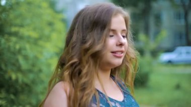 Genç bir kızın etrafında döner ve ileri saçlarını geliştirme gider. Ağır çekim.