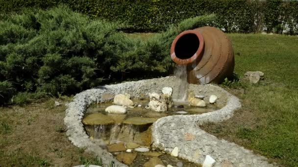 Le décor dans le parc. D'une grande cruche d'eau coule et devient un petit ruisseau . — Video