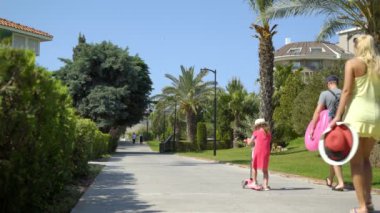 Güzel yeşil sokak bahar, palmiye ağaçları ile aile tarafından geçer