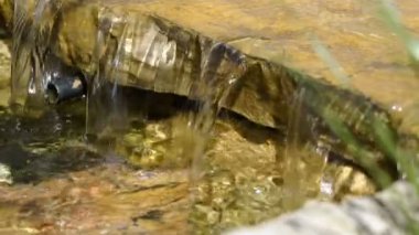 Dekor parkta küçük bir şelale, yavaş hareket su kayalardan düşüyor..