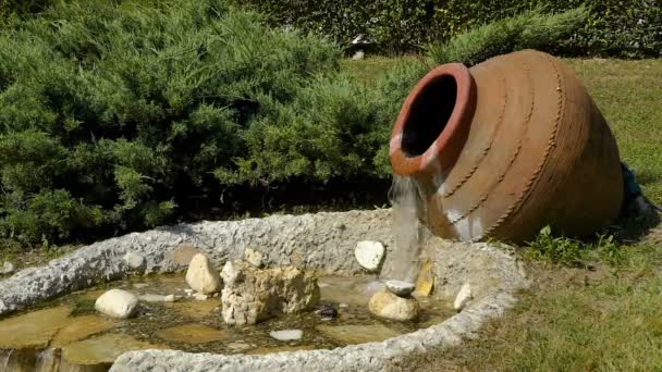 Le décor dans le parc. Mouvement lent à partir d'une grande cruche d'eau coule et devient un petit ruisseau . — Video