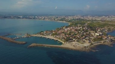 Uçuş demirli tekneler ve düşük binalar ile Yarımadası çevresindeki. Dron kıyıya uçar. Üstten görünüm deniz ve sahil.