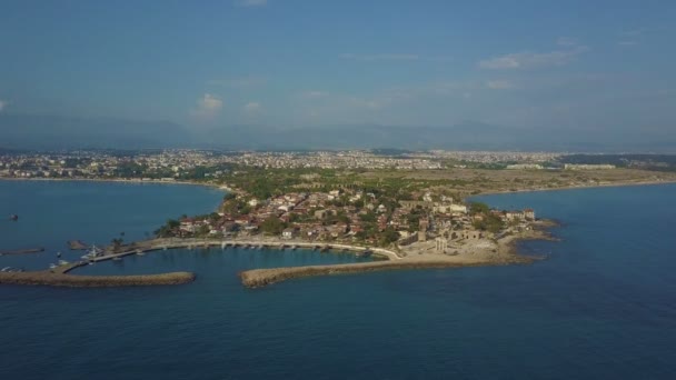 Volo intorno alla penisola con barche ormeggiate ed edifici bassi. Vista dall'alto sul mare e sulla costa . — Video Stock