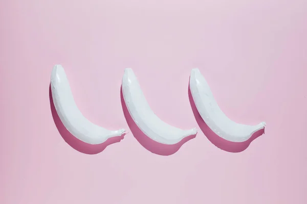 Pembe bir arka plan üzerinde beyaz banana