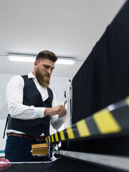 Портной молодой человек, работающий над новой одеждой