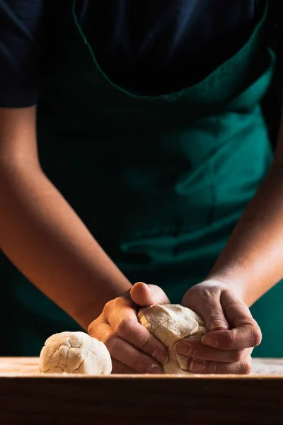 Hands of a chef baker woman kneading dough