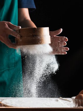 Hands of a chef baker woman kneading dough clipart