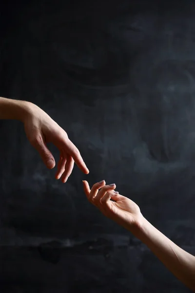 hands of people in symbol of relationships, black background
