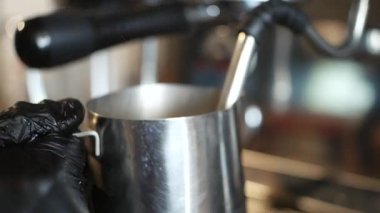 Bir kapuçino için yağsız süt köpüğü yapıyorum.