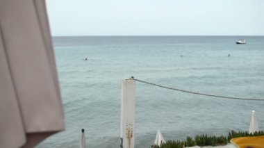 Beyaz iple bağlanmış tahta sütunlar terasın ucunu işaret ediyor.