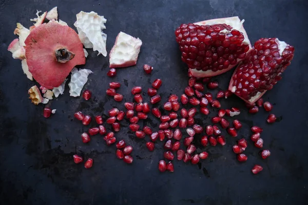 karanlık bir arka plan üzerinde kırmızı, olgun nar nar meyve ile dilimlenmiş