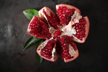 kırmızı, olgun nar ahşap arka plan, nar suyu, nar yararlı özellikleri yeşil yaprakları ile kesmek