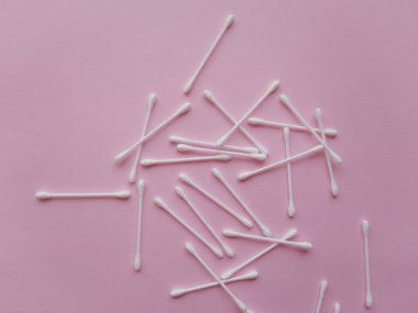 Yukarıdan plastik pamuk tomurcukları pembe bir arka plan düz lay, tarih görüntüleme