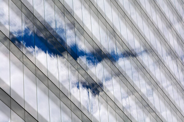 Облака и голубое небо отражались на окнах зданий
