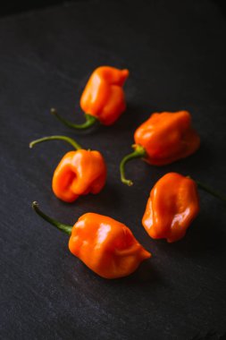 Kayrak bir yüzey üzerinde ham turuncu habaneros gruplandırması