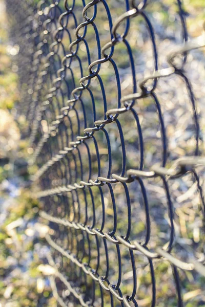 Suivre l'angle descendant d'une clôture à maillons de chaîne en milieu urbain . — Photo