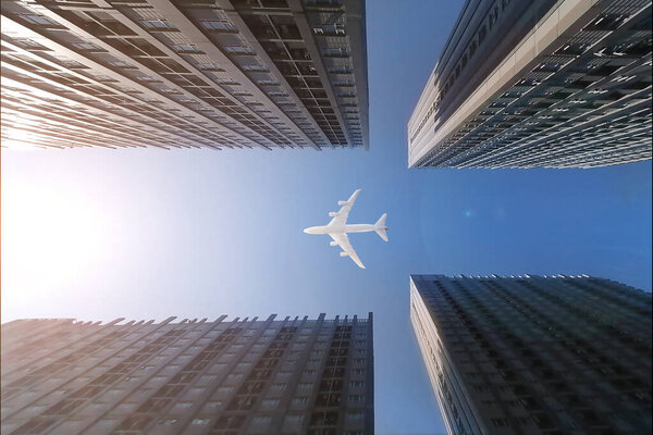 Airplane flying over business skyscrapers, high-rise buildings. transportation on blue sky.