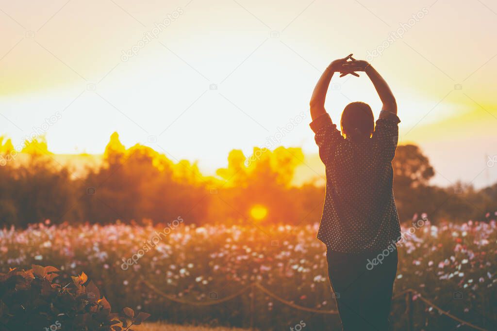 cheering woman open arms at sunrise flowers garden,Nature of Life